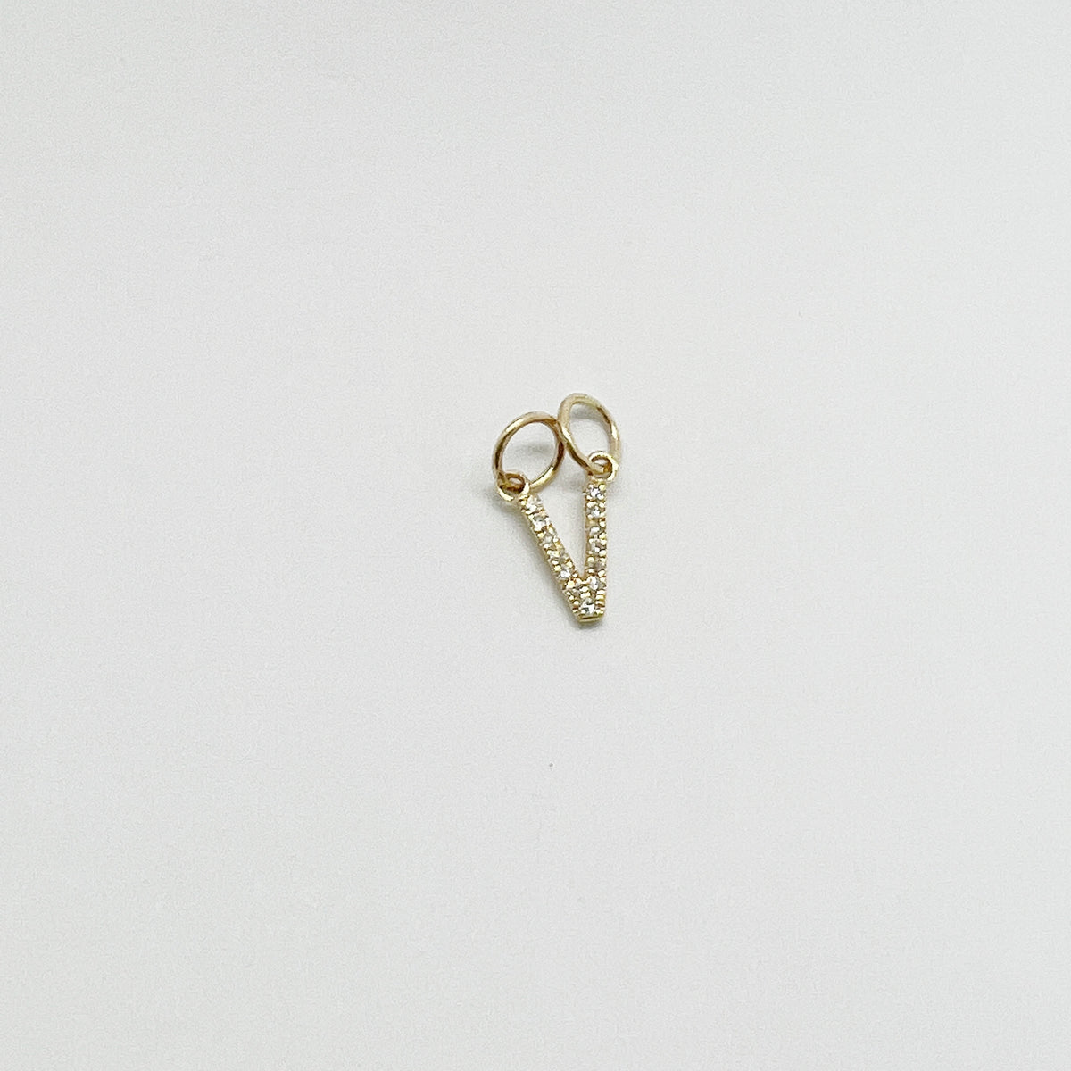 Dije letra V con diamantes