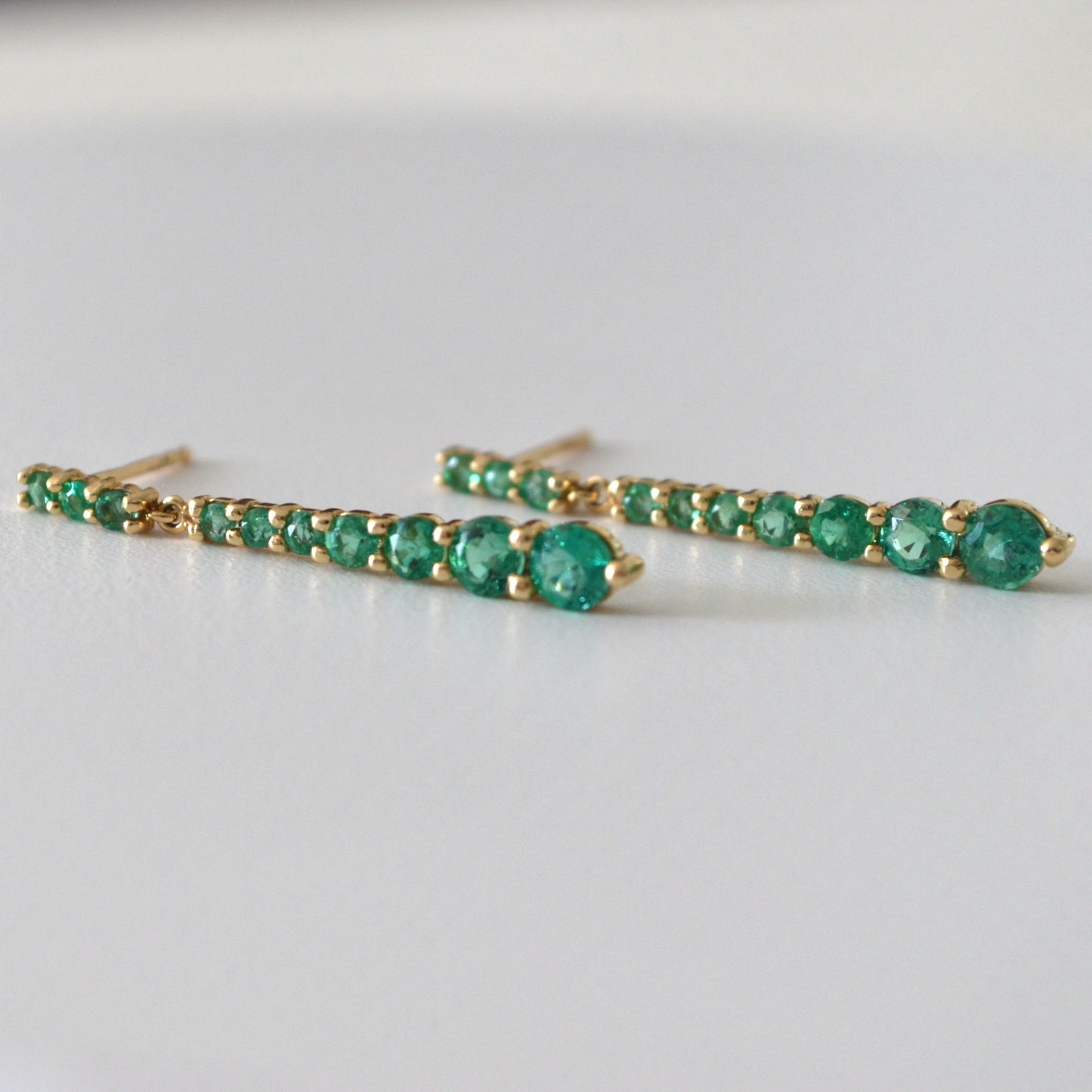 Aretes colgantes en oro amarillo 14K con Esmeraldas